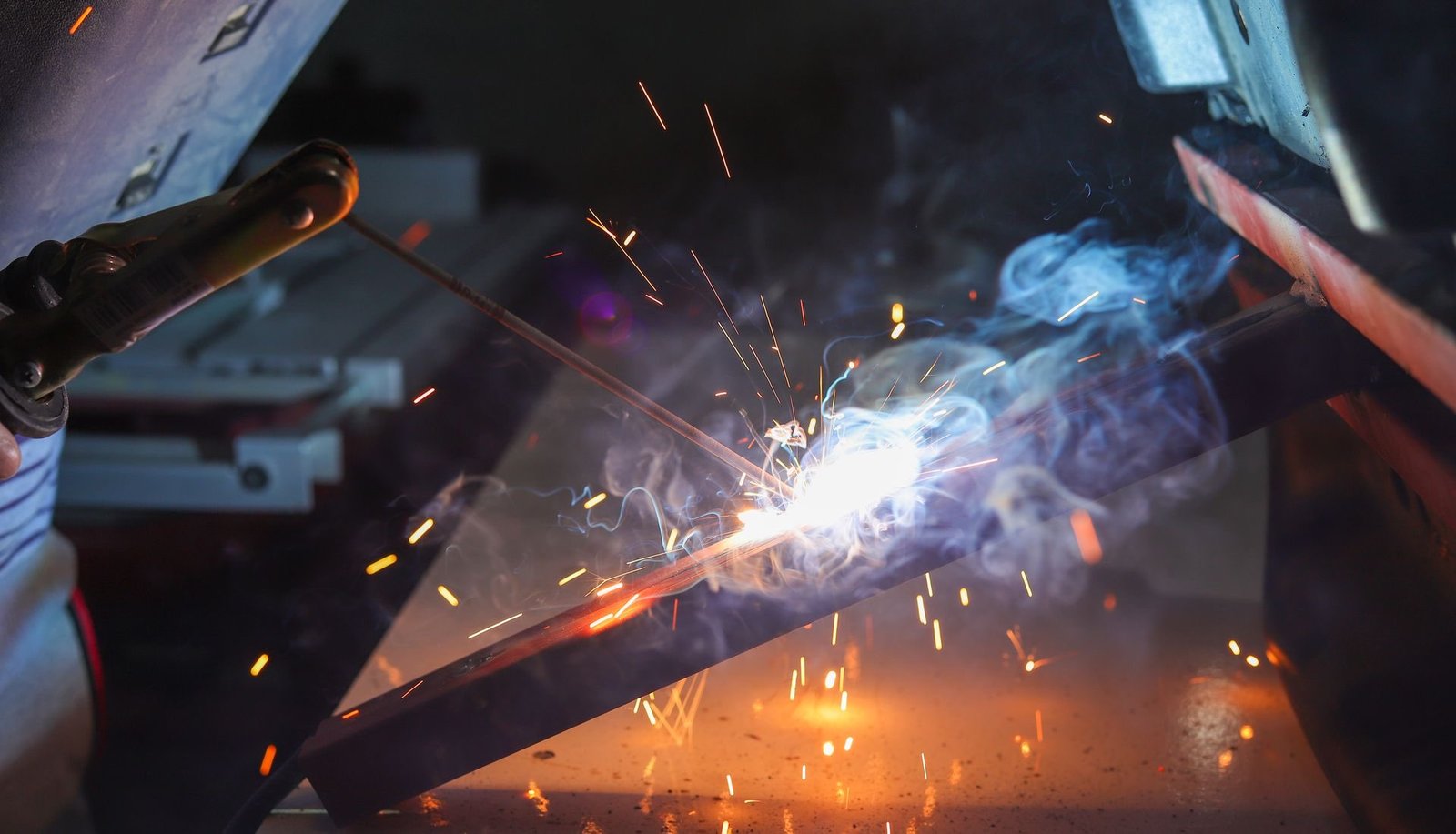 Steel fabrication welding with sparks and a bright arc